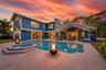 Exterior featuring vertical siding, concrete patio, swimming pool with integrated spa, and covered lanai