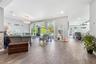 Open-concept living space featuring wood-finish flooring, recessed lighting, a statement crystal chandelier, and sliding glass doors