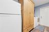Utility space featuring wood-finish flooring, a six-panel exterior door, and white appliances