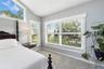Vaulted ceiling, neutral wall tones, carpeted flooring, and oversized windows with white trim