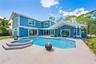 Board-and-batten siding exterior featuring a covered patio, swimming pool, integrated spa, and concrete deck