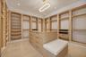 fully built out custom closet with storage bench