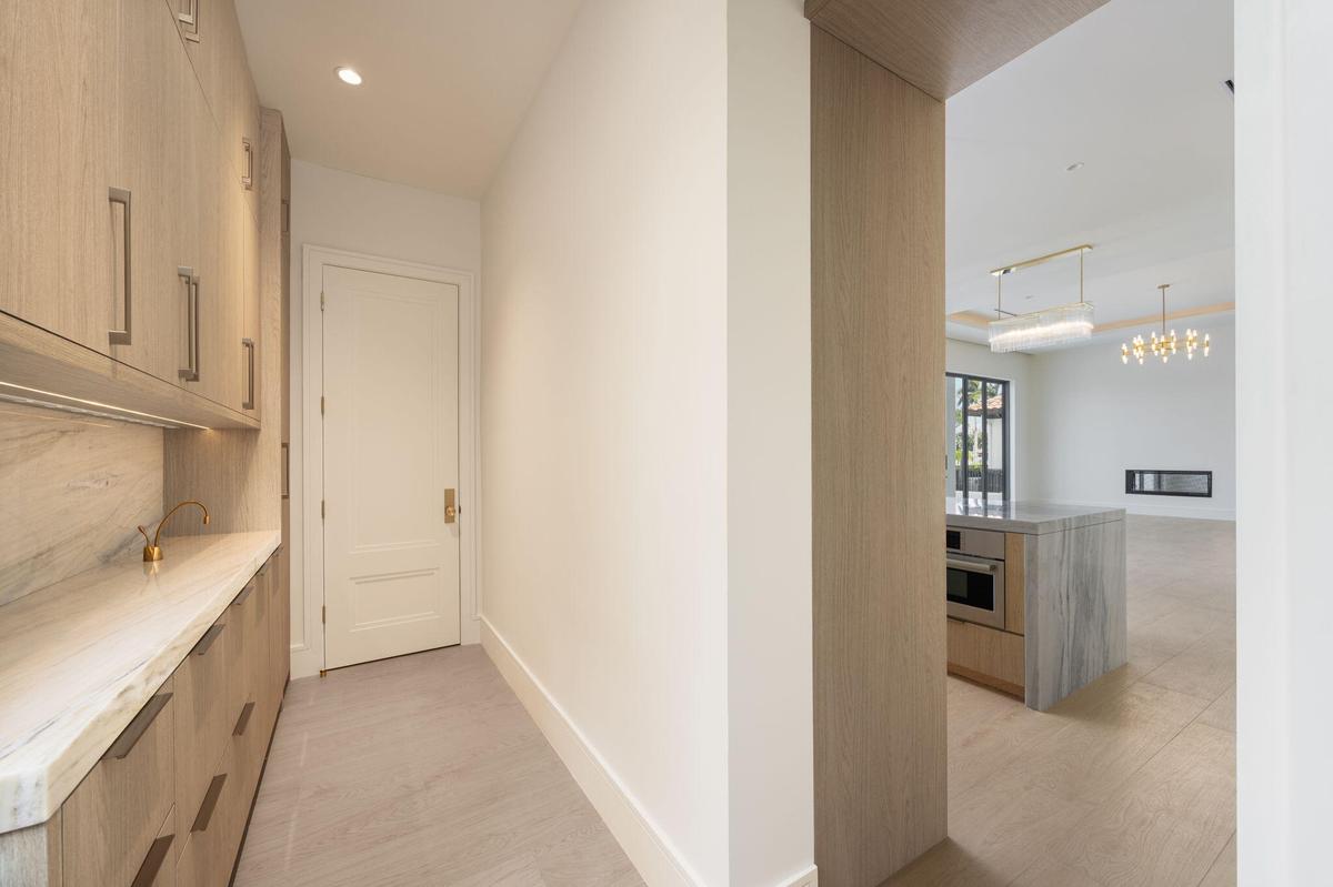pantry floor to ceiling cabinetry , marble counter & backsplash and instahot faucet. ac closet at end of room