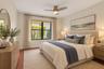 Room featuring wood-finish flooring, a ceiling fan with integrated lighting, a rectangular window with dark framing, and neutral wall tones -virtually