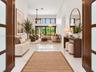 Impact front doors open to living room and dining room. virtually staged