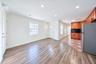 Wood-finish flooring, recessed lighting, wood cabinetry, patterned tile flooring, and a stainless steel refrigerator
