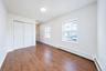 Room featuring wood-finish flooring, dual-pane windows with muntin bars, and a double-door closet