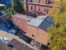 Multi-story brick exterior featuring a flat roofline and integrated off-street parking