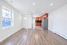 Open floor plan featuring wood-finish flooring, recessed lighting, and kitchen cabinetry with integrated appliances