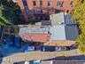 Aerial perspective of a multi-story brick exterior featuring a low-slope roof system and concrete surface parking area