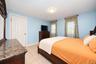 Neutral tile flooring, multi-panel interior door, and dual windows with grid detailing