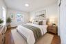 Room featuring wood-finish flooring, dual-pane windows, neutral wall palette, and bi-fold closet doors
