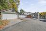 Exceptional property layout featuring a detached 2-car garage, expansive driveway parking for up to 4 additional vehicles, and a custom outdoor kitche