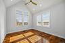 Vaulted ceiling with recessed lighting, wood-finish flooring, and expansive windows