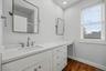 Extended vanity featuring a stone countertop, under-mount sink, white cabinetry with pull-out drawers, recessed lighting, and wood-finish flooring