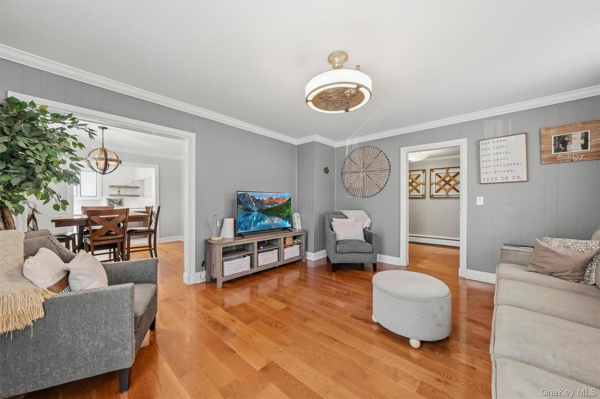 Spacious and sunlit living room highlighted by rich hardwood flooring and a comfortable layout for everyday living.