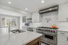 Gourmet chef's kitchen featuring top-of-the-line professional appliances, custom cabinetry, extensive counter space, and a large center island designe