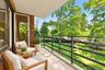 Covered balcony featuring exposed brick wall, concrete flooring, and horizontal metal railing