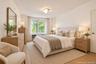 Neutral interior featuring light-tone wood-finish flooring, multi-globe flush-mount lighting, and an expansive window with natural exterior scenery