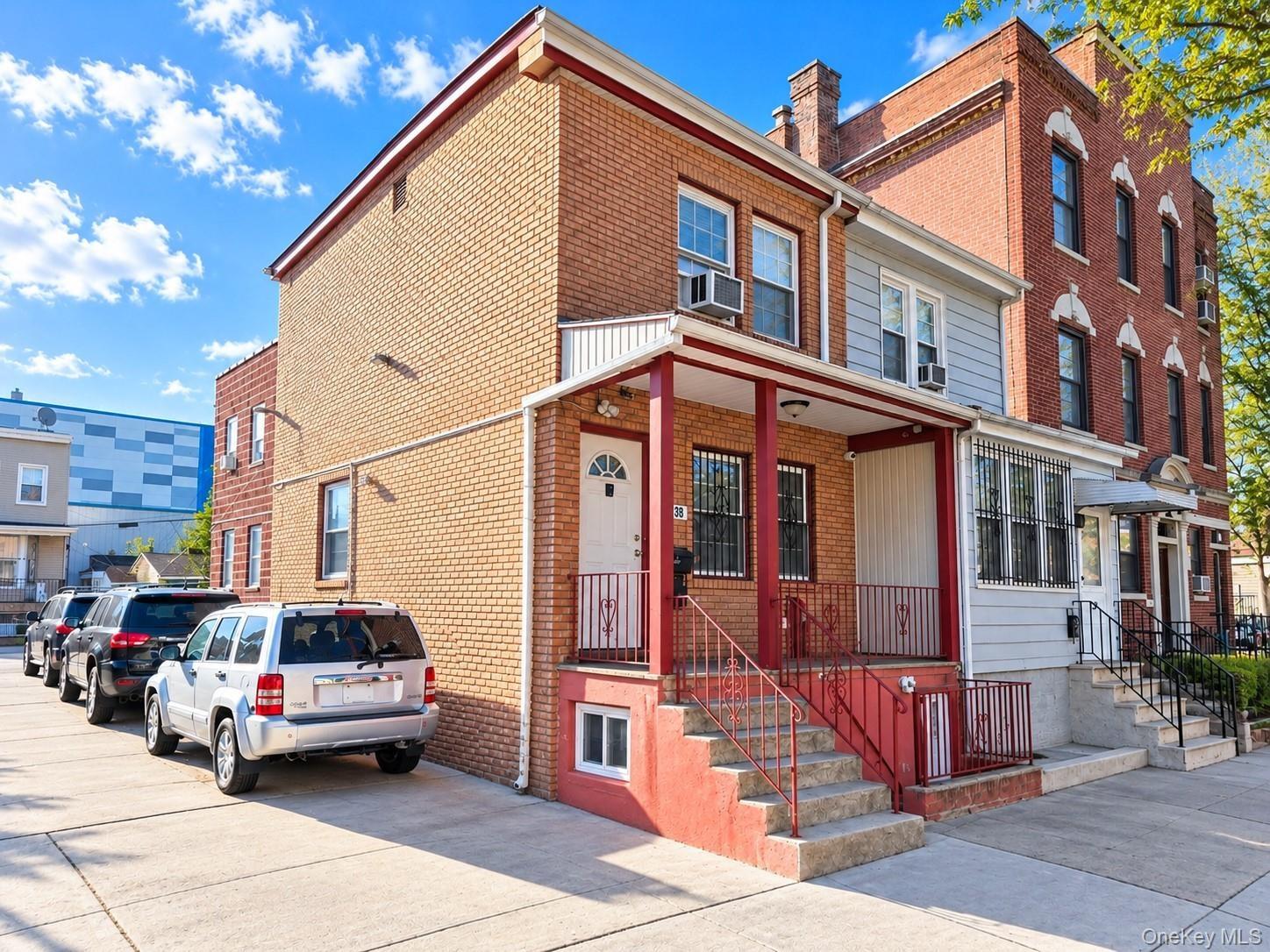 Brick exterior featuring a covered front porch, concrete steps, metal railings, and private off-street parking