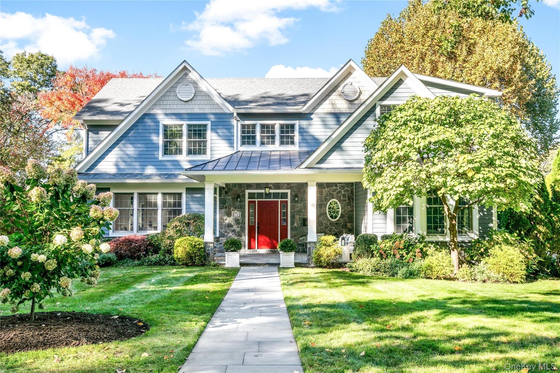 Beautifully maintained 2013-built Center Hall Colonial clad in stone and hardiplank with welcoming covered porch and professionally landscaped grounds