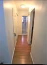 Corridor with light wood-type flooring and baseboards