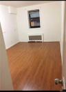 Empty room with dark wood-style floors and radiator heating unit