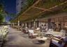 Covered outdoor patio featuring an overhead pergola with integrated landscape climbing vines, stone-tiled flooring, and recessed wall-mounted lighting