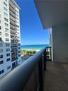 Private balcony featuring a metal and glass railing, concrete flooring, and an expansive ocean backdrop