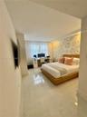 Large-format polished floor tile, recessed ceiling lighting, and a prominent decorative feature wall