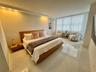 Spacious room featuring polished tile flooring, recessed cove lighting, and floor-to-ceiling sheer window treatments