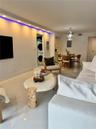 Interior space featuring large-format tile flooring, recessed ceiling lighting with integrated colored accent strips, and a designated laundry area eq