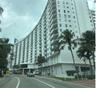 High-rise residential exterior featuring a curved facade, private balconies, and an arched ground-level entryway