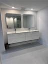 Double floating vanity featuring a white composite countertop, dual integrated sinks, chrome faucets, and two rectangular wall-mounted mirrors with in