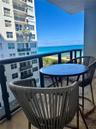 Private balcony featuring a black metal railing and concrete flooring, overlooking the ocean and coastline