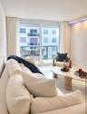 Large sliding glass door, white tile flooring, recessed ceiling lighting with accent illumination, and private balcony