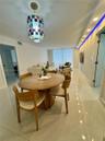 Polished tile flooring, recessed ceiling lighting, decorative multi-colored glass pendant fixture, and recessed cove lighting with blue accent