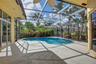Screened-in patio featuring a concrete deck, swimming pool, and ceiling fan