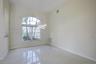 High-ceilinged room featuring large arched window, polished tile flooring, and contemporary multi-ring pendant lighting