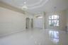Open-concept interior featuring high tray ceilings, polished tile flooring, arched doorways, a double-entry door with transom window, and an expansive
