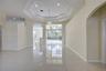 Open interior featuring polished tile flooring, tray ceilings with recessed lighting, an architectural archway, and expansive floor-to-ceiling glass p