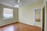 Room featuring wood-finish flooring, a multi-light ceiling fan, and a single-pane window