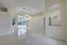 Octagonal tray ceiling, polished tile flooring, contemporary circular chandelier, arched wall cutouts, and expansive sliding glass doors