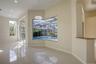 Open-concept interior featuring polished tile flooring, recessed lighting, a built-in stone-surface counter, and large windows encompassing a screened