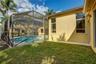 Screened-in pool enclosure featuring a concrete patio deck, stucco exterior walls, and tall vertical windows