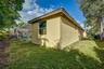 Stucco exterior, screened-in swimming pool enclosure, and mature landscaping