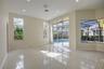 High ceilings with recessed lighting, large-format tile flooring, multi-light pendant fixture, floor-to-ceiling windows, and sliding glass doors openi