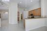Kitchen featuring stone countertops, natural wood-finish cabinetry, built-in stainless steel appliances, recessed ceiling lighting, and tile flooring 