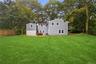 Expansive lawn featuring mature trees, a wood privacy fence, and a patio area