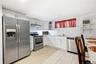 Kitchen featuring white shaker-style cabinetry, stainless steel appliances, white subway tile backsplash, light wood-finish flooring, and floating wal